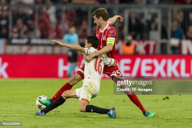 Jesus Navas of Sevilla and Thomas Mueller of Muenchen battle for the ball during the UEFA Champions League quarter final second leg match between...