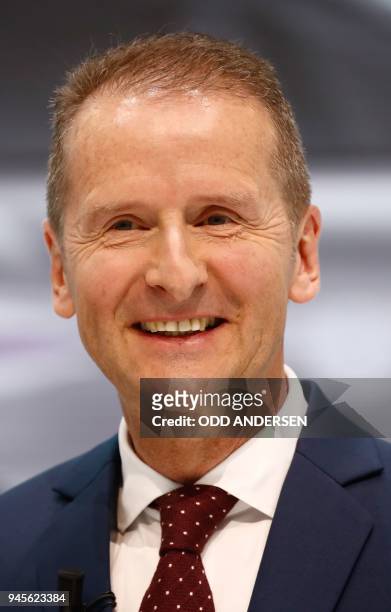 Newly appointed CEO of German car maker Volkswagen Herbert Diess smiles as he gives a press conference at the company's headquarters in Wolfsburg,...