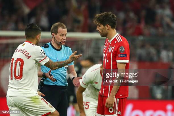 Ever Banega of Sevilla speaks with Referee William Collum and Javi Martinez of Muenchen during the UEFA Champions League quarter final second leg...