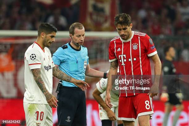 Ever Banega of Sevilla, Referee William Collum and Javi Martinez of Muenchen look on during the UEFA Champions League quarter final second leg match...