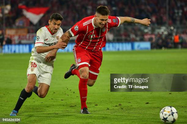 Jesus Navas of Sevilla and Niklas Suele of Muenchen battle for the ball during the UEFA Champions League quarter final second leg match between...