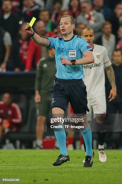 Referee William Collum shows a yellow card during the UEFA Champions League quarter final second leg match between Bayern Muenchen and Sevilla FC at...