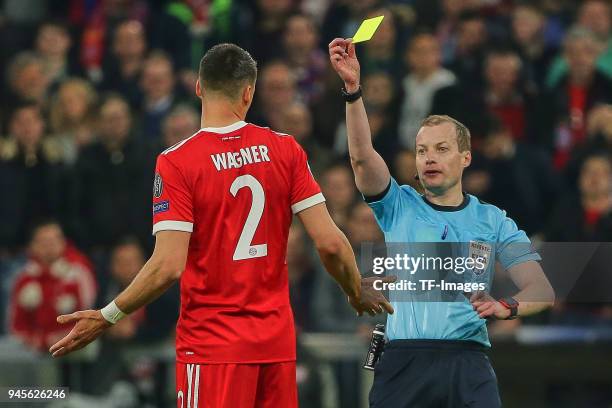 Referee William Collum shows a yellow card to Sandro Wagner of Muenchen during the UEFA Champions League quarter final second leg match between...