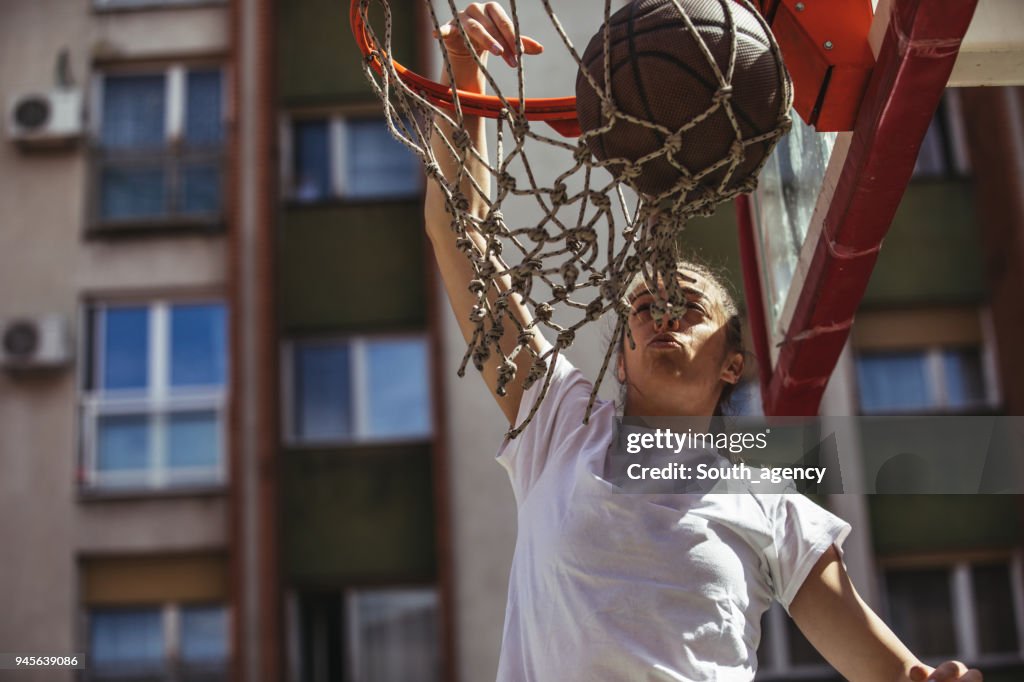 W9oman jogador de basquete fazendo um slam dunk