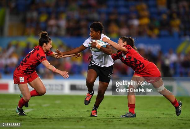 Ana Naimasi of Fiji is tackled by Sinead Breeze and Kayleigh Powell of Wales during the Rugby Sevens Women's Pool B match between Fiji and Wales on...