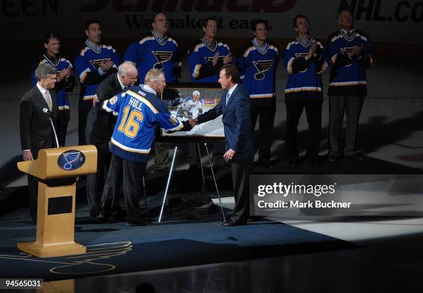 Brett Hull shakes hands with Peter McLoughlin of the St. Louis Blues during the Hall of Fame night before a game against the Calgary Flames on...