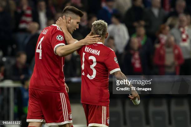 Niklas Suele of Muenchen speaks with Rafinha of Muenchen during the UEFA Champions League quarter final second leg match between Bayern Muenchen and...