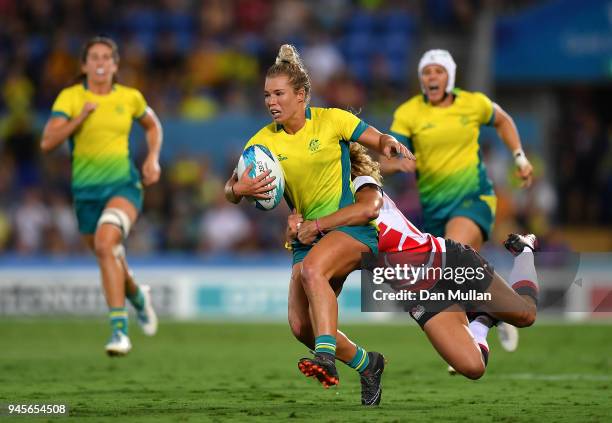 Emma Tonegato of Australia is tackled by Deborah Fleming of England during the Rugby Sevens Women's Pool B match between Australia and England on day...
