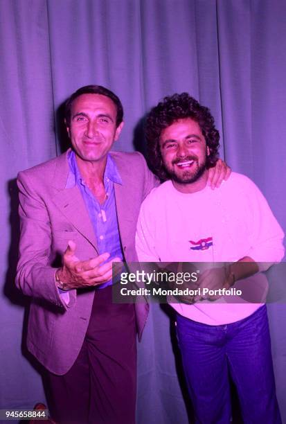 The comedian Beppe Grillo and the TV host Pippo Baudo in the backstage of Vota la voce. 1979