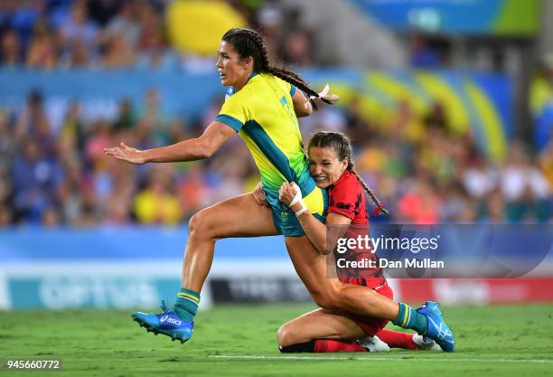 Charlotte Caslick of Australia is tackled by Jasmine Joyce of Wales during the Rugby Sevens Women's Pool B match between Australia and Wales on day...