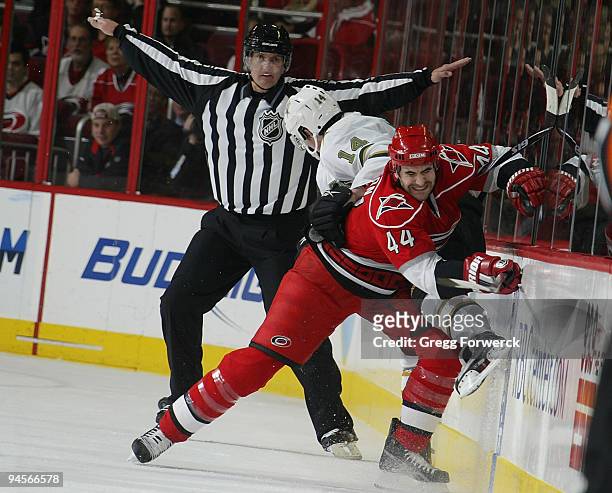 Jay Harrison of the Carolina Hurricanes checks Jamie Benn of the Dallas Stars into the boards during a NHL game on December 16, 2009 at RBC Center in...