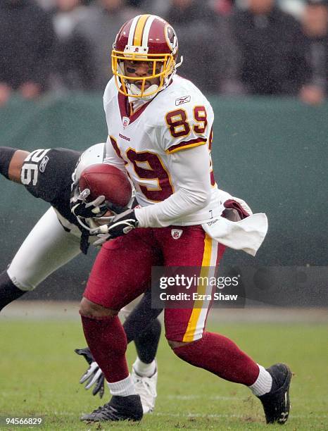 Santana Moss of the Washington Redskins runs with the ball during their game against the Oakland Raiders at Oakland-Alameda County Coliseum on...