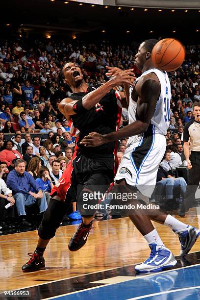 Chris Bosh of the Toronto Raptors passes against Brandon Bass of the Orlando Magic on December 16, 2009 at Amway Arena in Orlando, Florida. NOTE TO...