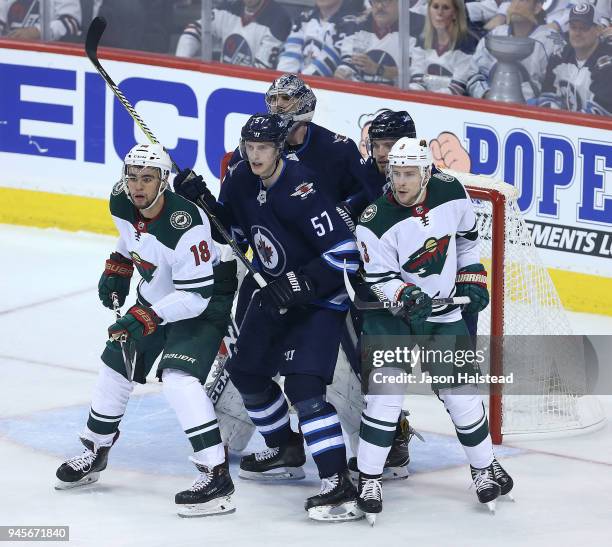 Jordan Greenway and Charlie Coyle of the Minnesota Wild crowd the Winnipe goal in front of Tyler Myers, Ben Chiarot and Connor Hellebuyck of the...