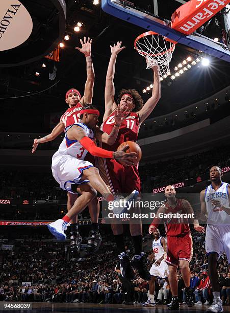 Allen Iverson of the Philadelphia 76ers passes the ball against Delonte West and Anderson Varejao of the Cleveland Cavaliers during the game on...