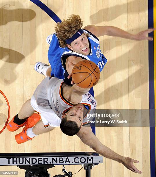 Nick Collison of the Oklahoma City Thunder goes for a rebound against Dirk Nowitzki of the Dallas Mavericks during the game at the Ford Center on...