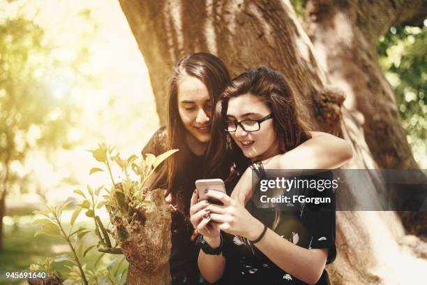 girlfriends browsing on the telephone - 2017 common good forum stock pictures, royalty-free photos & images