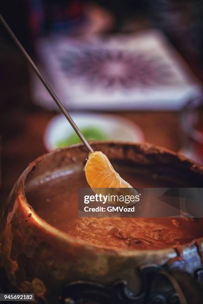 doppning tangerine i chokladfondue - chokladfondue bildbanksfoton och bilder