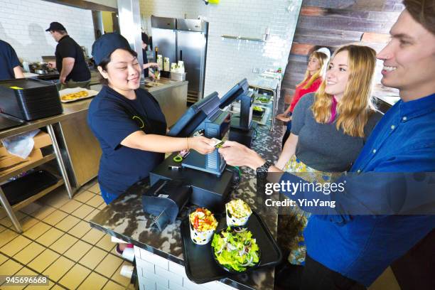 kitchen and wait staff serving customers in fast food restaurant checkout - burger king imagens e fotografias de stock