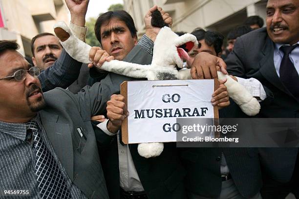 Pakistani lawyers pull at a toy dog with the sign "Go Musharaf Go" during a protest near the district court in Islamabad, Pakistan, on Saturday, Nov....