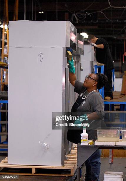 Theresa Adams, of Sewell, New Jersey, left, gives a final clean to a completed refrigeration unit at Victory Refrigeration, Inc., in Cherry Hill, New...