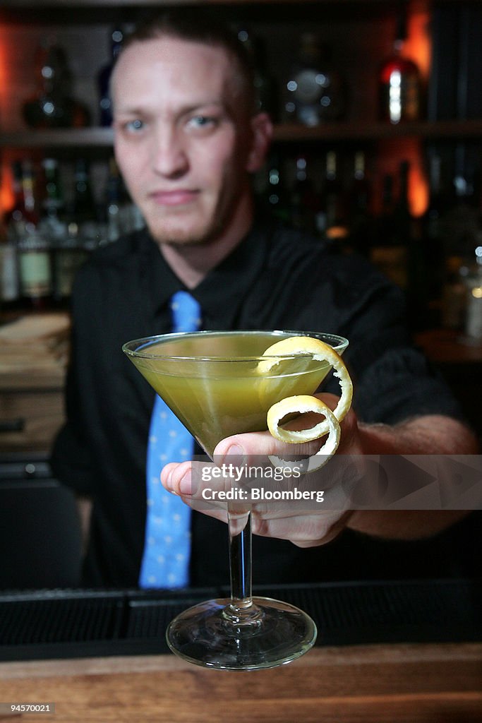 Bartender Jesse Belardo holds up a green tea martini at Blue