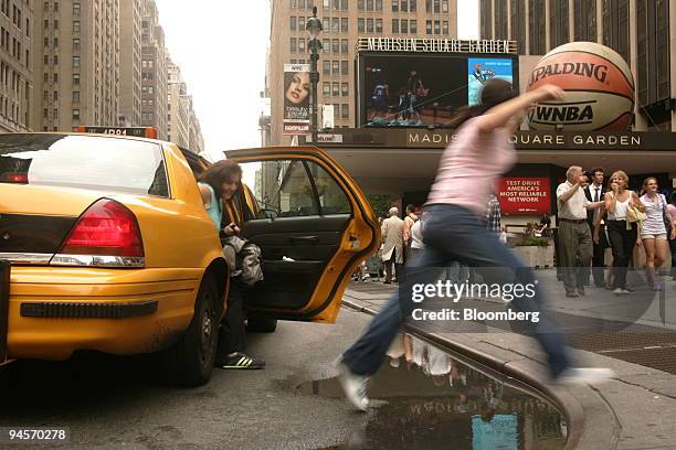 Alexa Fumerton jumps over a puddle outside Penn Station in New York, Wednesday, July 18, 2007. Thunderstorms pounded the region with heavy rains this...