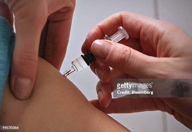 Nurse administers CSL Ltd.'s Enzira seasonal flu vaccine to a patient at a Boots pharmacy in Holborn, London, U.K., on Thursday, Nov. 8, 2007....