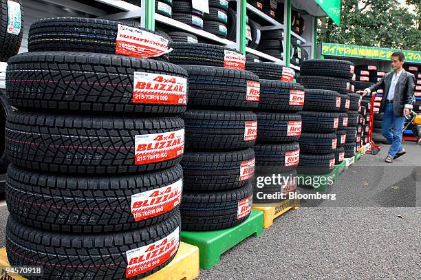 Customer looks at tires made by Bridgestone Corp. That have been stacked up at a Bridgestone outlet in Tokyo, Japan, on Thursday Nov. 1 2007....