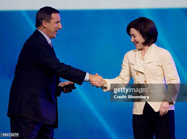 Mark Hurd, chairman, president, and chief executive officer of Hewlett-Packard Co., left, shakes hands with Safra Catz, president and chief financial...