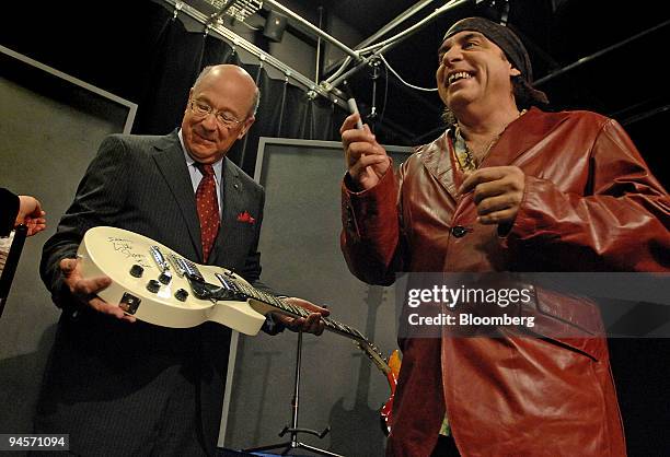 John Mahlmann, left, executive director of the National Association for Music Education, holds a Gibson Les Paul guitar autographed by "Little"...