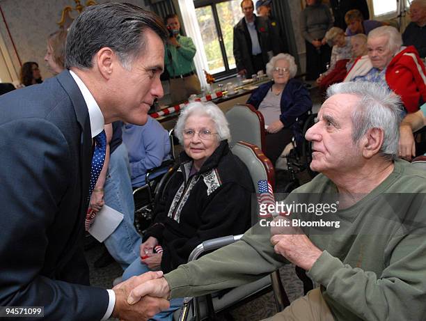 Mitt Romney, left, former governor of Massachusetts and 2008 Republican presidential candidate, greets World War II Navy veteran Richard Chiarla at...