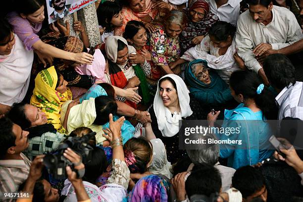 Former Pakistan Prime Minister, Benazir Bhutto, center, visits the family home of Zaheer Abbas Bolas, a Pakistan Peoples Party supporter killed in...