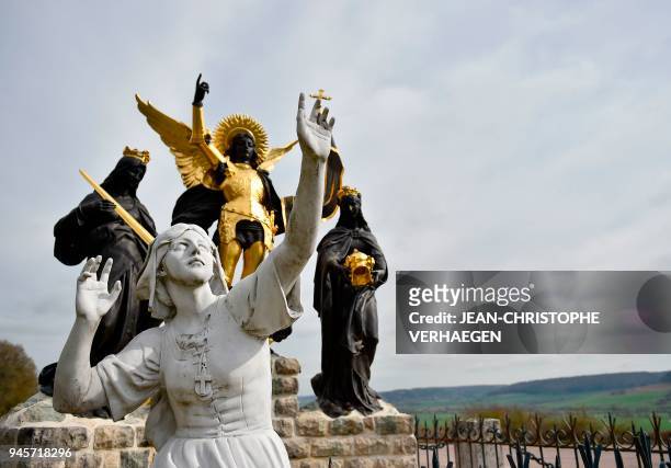The sculpture "Jeanne d'Arc and his voices" is pictured in front of Bois-Chenu's basilica, dedicated to Jeanne d'Arc , on April 12, 2018 in...