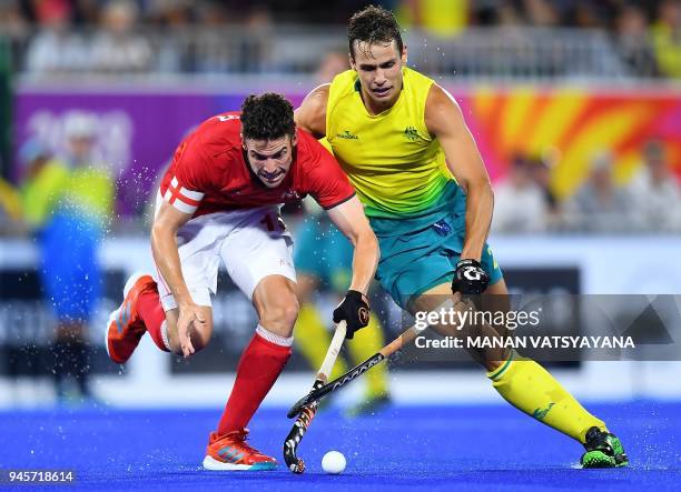 Phillip Roper of England fights for the ball with Australia's Tom Craig during their men's field hockey semi-final match at the 2018 Gold Coast...