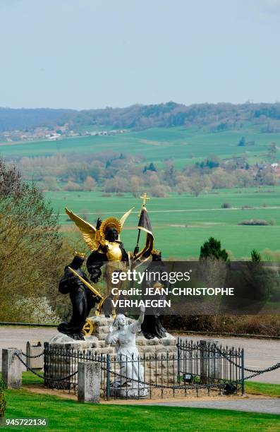 The sculpture "Jeanne d'Arc and her voices" is pictured in front of Bois-Chenu's basilica, dedicated to Jeanne d'Arc , on April 12, 2018 in...