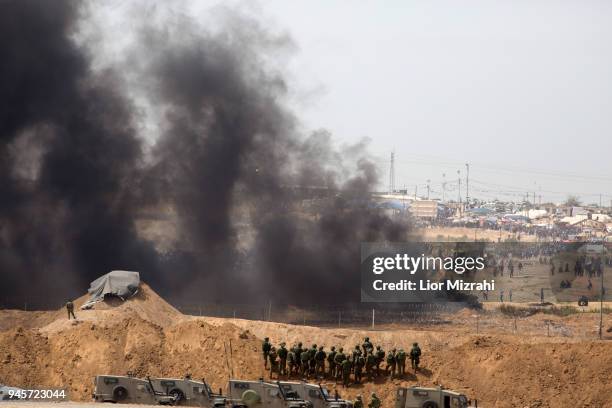 Israeli soldiers take positions as Palestinian gathered for a protest on the Israel-Gaza border on April 13, 2018 in Netivot, Israel. Thousands of...