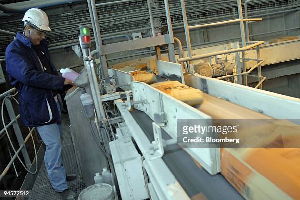 Lafarge worker checks the controls on the production line, for bagged cement at the factory in Port la Nouvelle, France, on Monday, Nov. 5, 2007....