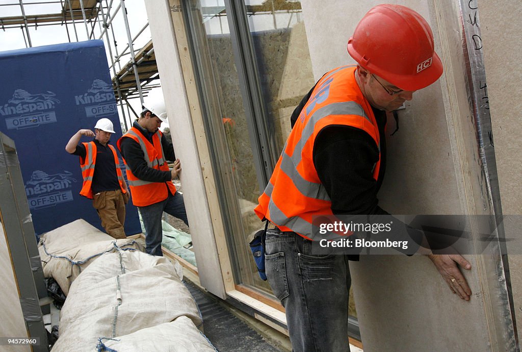 Builders move sections of an Ikea prefabricated home into pl