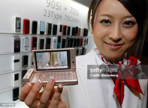 Model displays NTT DoCoMo Inc.'s new P905i mobile phone during a product launch event in Tokyo, Japan, on Thursday, Nov. 1, 2007. NTT DoCoMo Inc.,...