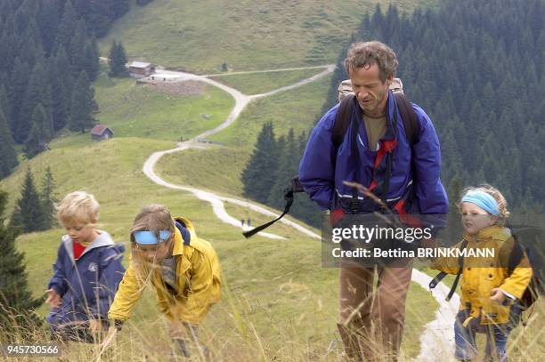 Un pere fait une randonnee en montagne avec ses enfants de 7,5 et 4 ans.