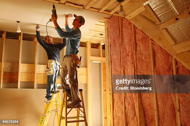 Mike Kelly, left, and Seth Warner hang drywall in a new home under construction in Peacham, Vermont, U.S., on Tuesday, Oct. 30, 2007. Spending on...