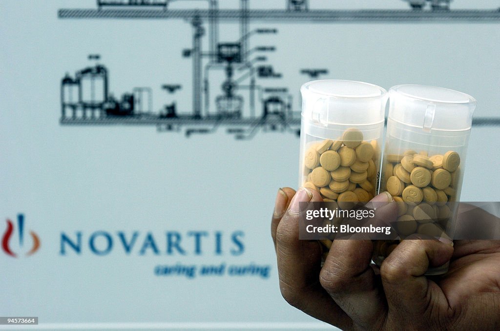 A worker holds containers of test tablets made in the Novart