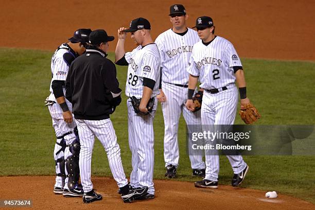 Bob Apodaca, pitching coach for the Colorado Rockies, second from the left, speaks to pitcher Aaron Cook, center, and infielders during Game 4 of the...