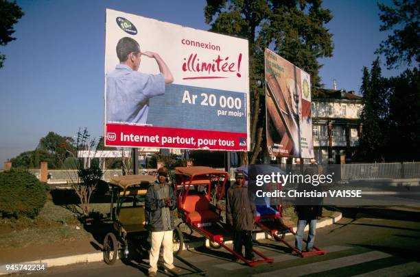 Contraste entre le pousse pousse archaique et la publicite pour internet illimite.