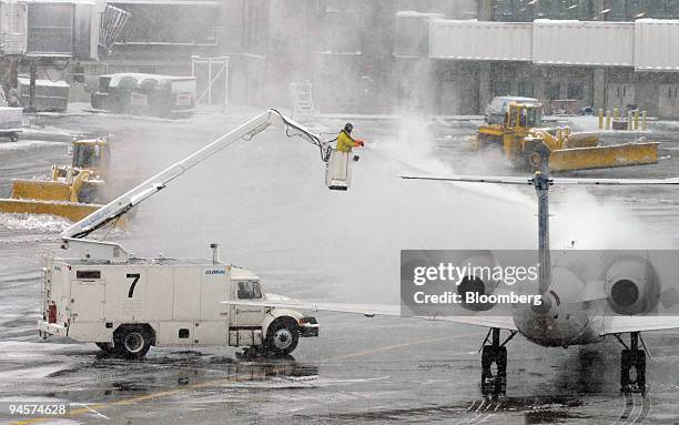 Snow removal and de-icing crews work at Logan Airport in Boston, Massachusetts, U.S., on Monday, Jan. 14, 2008. A rapidly moving nor'easter dumped...