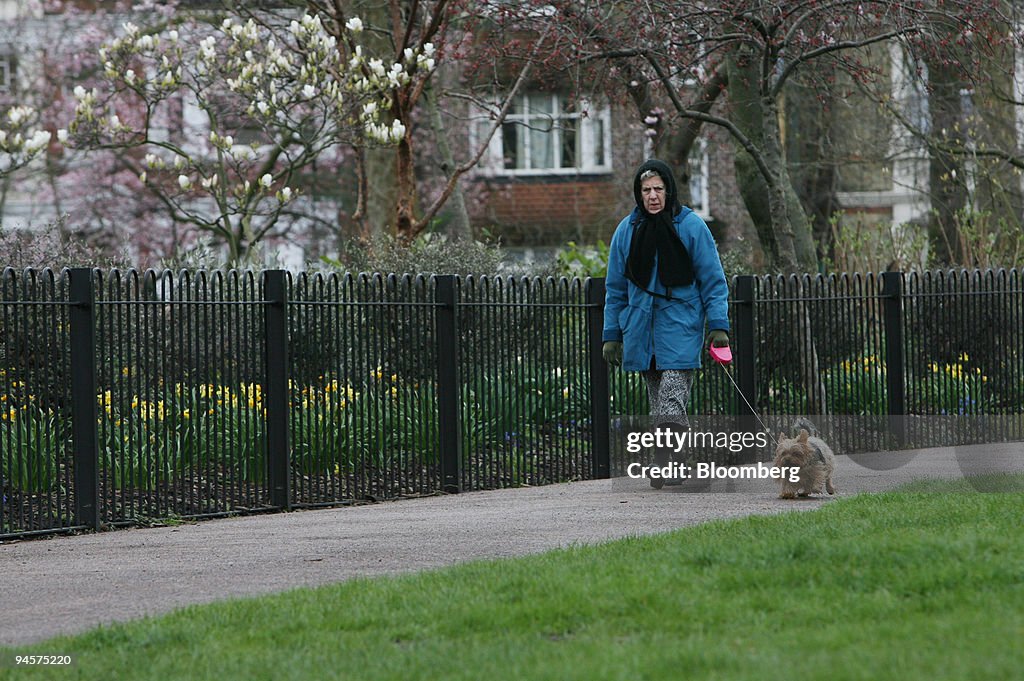 A pensioner walks her dog through Queens Park in London, U.K