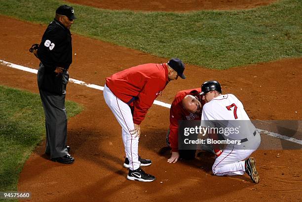 Drew of the Boston Red Sox, No. 7, talks to manager Terry Francona, second from the left, and an athletic trainer after getting hit by a pitch by...