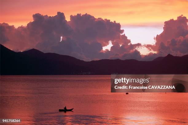 COUCHER DE SOLEIL ET CAYUCOS, LAC ATITLAN, GUATEMALA.