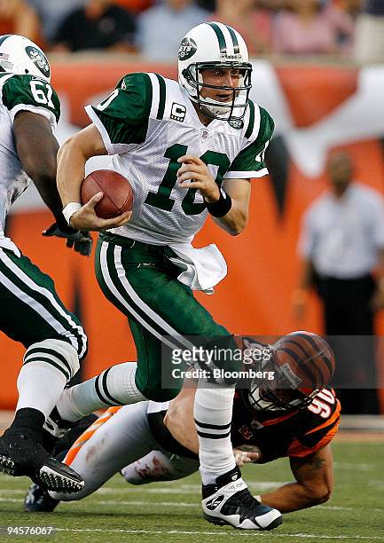 Chad Pennington, No. 10, quarterback for the New York Jets, scrambles to break free from Justin Smith of the Cincinnati Bengals during the fourth...